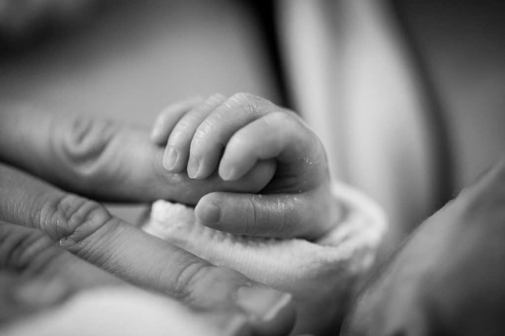 תינוק מחזיק יד של ההורה